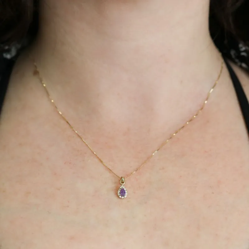 A drop-shaped halo pendant with an amethyst stone on a 14K gold chain.